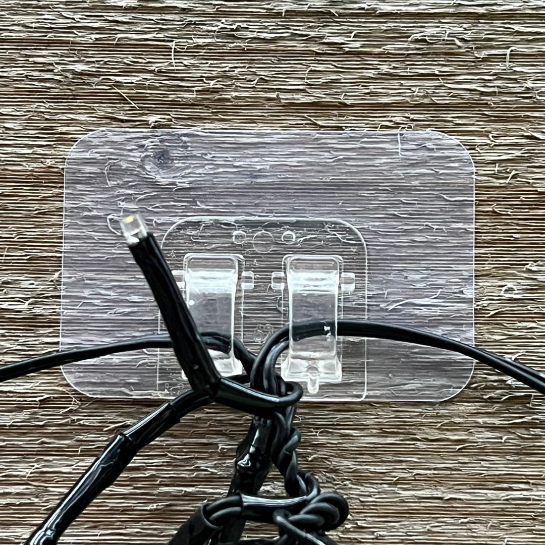 StickyClips Pro met lichtsnoer op een houten ondergrond